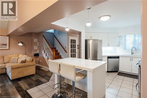 Open-concept kitchen featuring white cabinetry, stainless steel appliances, and a central island with countertop seating - 171 Mcnichol Drive, Cambridge, ON 