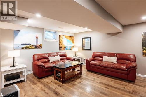 Spacious open-concept living area featuring wood-finish flooring, recessed lighting, and light gray wall paint - 171 Mcnichol Drive, Cambridge, ON 