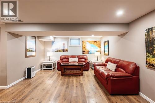 Recessed ceiling lighting illuminates the spacious room with wood-finish flooring, light neutral wall paint, and white trim - 171 Mcnichol Drive, Cambridge, ON 