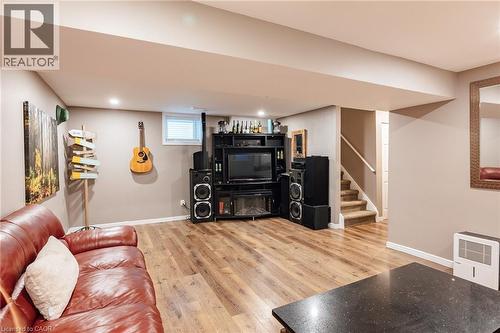 Open-concept lower level featuring wood-finish flooring, recessed lighting, and a built-in media console - 171 Mcnichol Drive, Cambridge, ON 