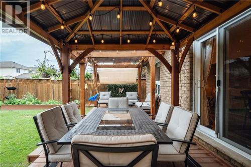 Covered patio featuring a corrugated metal roof, exposed wood beams, and string lighting - 171 Mcnichol Drive, Cambridge, ON 