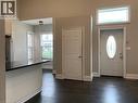 Unit 1 Open-concept living space featuring dark wood-finish flooring, a contemporary kitchen island with a dark countertop, and a white entry door with an oval-shaped decorative glass insert - 405 Macnab Street N, Hamilton, ON 