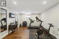 Finished lower level space featuring wood-finish flooring, recessed lighting, and a window - 