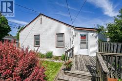 Rear exterior of the property featuring white horizontal siding and a wooden deck with railing - 