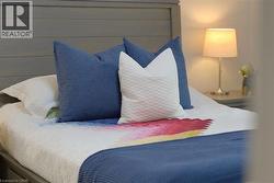 Shaker-style headboard in a muted gray finish, complemented by a bedside table with a contemporary lamp - 