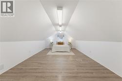 Bedroom Loft space featuring wood-finish flooring, white sloped ceilings, and recessed lighting - 