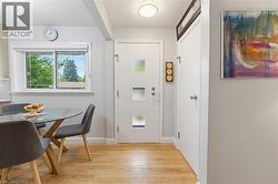 Entry area featuring wood-finish flooring, a white door with frosted glass inserts, and a flush-mount ceiling light - 