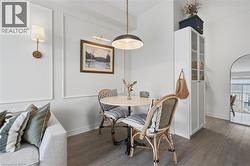 Defined dining area featuring a round pedestal table, overhead pendant lighting, and wood-finish flooring - 