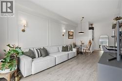 Light wood-finish flooring complements the white walls featuring panel molding - 
