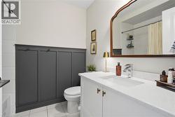 Bathroom featuring a white vanity with an integrated sink, polished chrome faucet, and gold-tone cabinet hardware - 