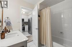 Bathroom featuring a white vanity with an integrated sink and a white subway tile shower/tub combination - 