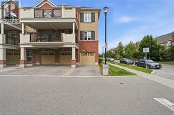 Multi-level townhome exterior featuring red brick and beige siding - 