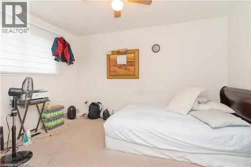 Carpeted room featuring a window with horizontal blinds, a ceiling fan with integrated lighting, and white painted walls - 574 Upper Sherman Avenue, Hamilton, ON 