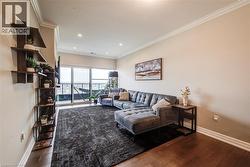 Living area featuring wood-finish flooring, recessed lighting, and crown molding - 