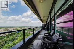 Expansive balcony featuring a glass and metal railing, patterned outdoor flooring, recessed ceiling lighting, and full-height windows - 