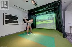 Dedicated golf simulator room featuring a projector and screen for virtual play - 
