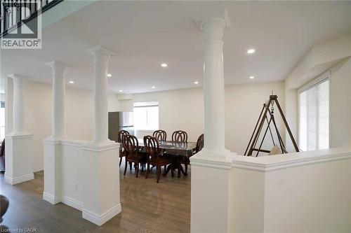 Open-concept interior featuring decorative columns, recessed lighting, wood-finish flooring, and crisp white walls - 187 Adler Drive, Cambridge, ON - Indoor