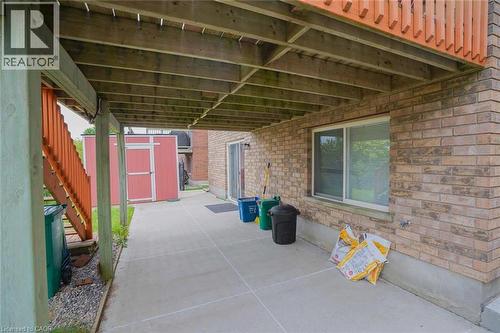Covered concrete patio with overhead wood joists, featuring a sliding glass door and a large sliding window - 187 Adler Drive, Cambridge, ON - Outdoor With Exterior