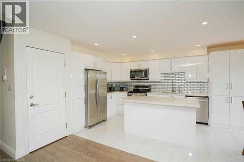 Modern kitchen featuring white gloss cabinetry, stainless steel appliances, a center island with a light-toned countertop, a subway tile backsplash, and recessed lighting - 187 Adler Drive, Cambridge, ON - Indoor Photo Showing Kitchen With Upgraded Kitchen