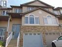 Multi-level townhouse exterior featuring light-toned siding and a stone facade - 214 Snowdrop Crescent, Kitchener, ON 