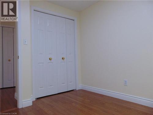 Room featuring wood-finish flooring, white baseboards, and light-toned walls - 214 Snowdrop Crescent, Kitchener, ON 
