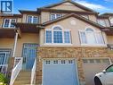 Multi-level townhouse exterior featuring stacked stone accents and neutral-toned siding - 214 Snowdrop Crescent, Kitchener, ON 