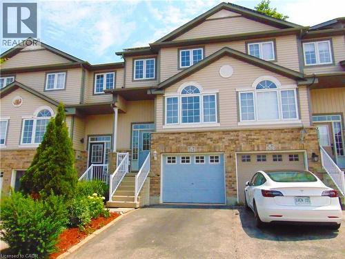Light beige siding exterior with stone facade accents - 214 Snowdrop Crescent, Kitchener, ON 