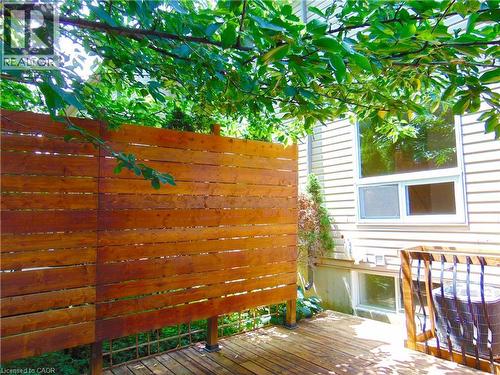 Wood-finish privacy screen on an exterior deck with natural wood planks - 214 Snowdrop Crescent, Kitchener, ON 