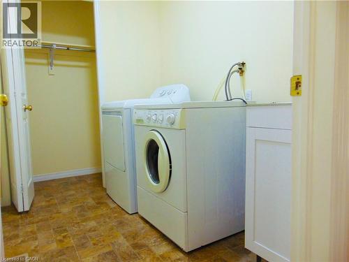 Utility area featuring a built-in cabinet with a countertop, tiled flooring, and an integrated closet with a hanging rod - 214 Snowdrop Crescent, Kitchener, ON 