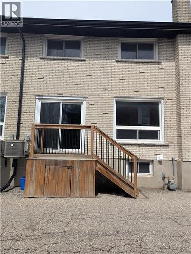 Exterior brick facade with a wooden deck featuring black metal balusters and built-in storage - 415-435 Garden Street Unit# 421, Cambridge, ON 