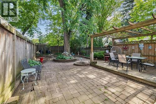Expansive outdoor living area featuring a paver patio and a raised wooden deck with an overhead pergola - 80 Maclennan Avenue, Hamilton, ON - Outdoor With Deck Patio Veranda