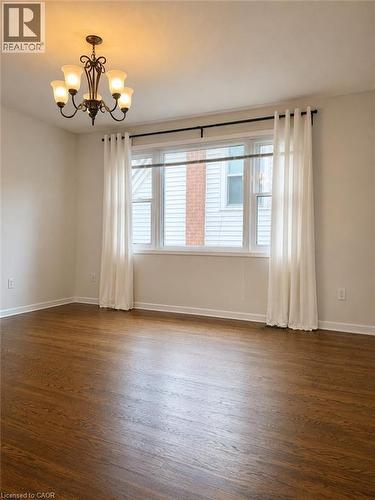 Hardwood flooring, multi-pane window, and a decorative ceiling light fixture - 80 Maclennan Avenue, Hamilton, ON - Indoor Photo Showing Other Room