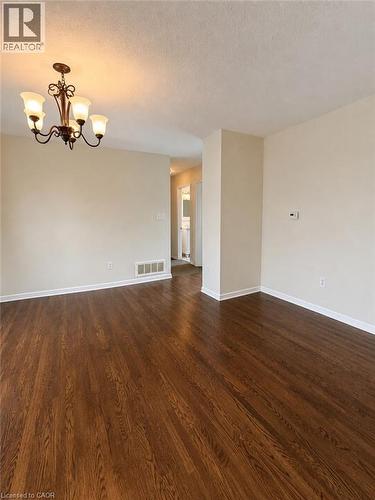 Wood-finish flooring throughout, complemented by light-toned wall paint and white trim - 80 Maclennan Avenue, Hamilton, ON - Indoor Photo Showing Other Room