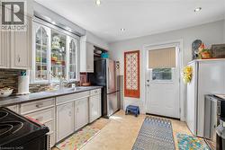 Kitchen featuring light-toned cabinetry, a mosaic tile backsplash, and a double basin sink with a gooseneck faucet - 