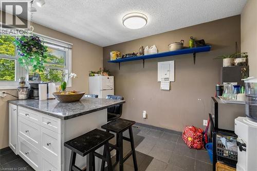 Kitchen island featuring a stone-finish countertop with built-in storage drawers - 80 Maclennan Avenue, Hamilton, ON 