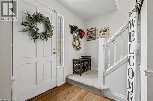 Entryway featuring a paneled door with a sidelight, wood-finish flooring, carpeted stairs with white banister, and white wall finishes - 80 Maclennan Avenue, Hamilton, ON - Indoor Photo Showing Other Room