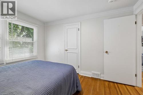 Hardwood flooring featuring a double-hung window with blinds, crown molding, and white trim - 80 Maclennan Avenue, Hamilton, ON - Indoor Photo Showing Bedroom