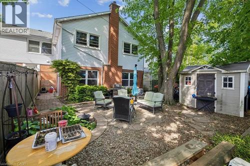 Expansive backyard featuring a stone patio, mature trees, a storage shed, and a privacy fence - 80 Maclennan Avenue, Hamilton, ON - Outdoor With Exterior