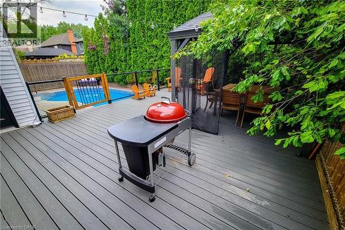Expansive gray composite decking with a black metal and glass railing system - 29 Woodside Square, Fonthill, ON - Outdoor With In Ground Pool With Deck Patio Veranda