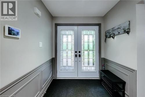 Double entry doors featuring decorative glass inserts and dark hardware - 29 Woodside Square, Fonthill, ON - Indoor Photo Showing Other Room