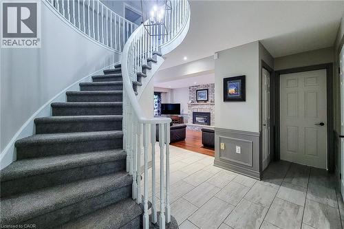 Curved staircase with carpeted treads and white wood balusters - 29 Woodside Square, Fonthill, ON - Indoor Photo Showing Other Room