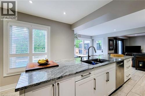 Kitchen island featuring a double basin sink, black faucet, and granite countertop - 29 Woodside Square, Fonthill, ON - Indoor Photo Showing Kitchen With Double Sink