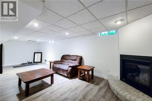 Spacious interior featuring wood-finish flooring, white walls, and a drop ceiling with recessed lighting - 29 Woodside Square, Fonthill, ON - Indoor With Fireplace