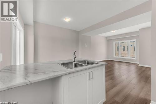 Kitchen island featuring a double basin stainless steel sink with a chrome faucet and a white marble-patterned countertop - 19 Picardy Drive Unit# 9, Hamilton, ON 
