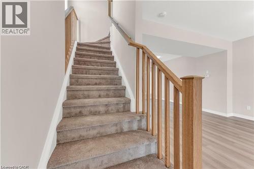 Carpeted staircase with natural wood-tone railings - 19 Picardy Drive Unit# 9, Hamilton, ON 