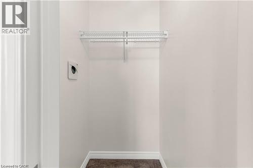 White-painted walls with white baseboards, a single wire shelf, and brown carpet flooring - 19 Picardy Drive Unit# 9, Hamilton, ON 