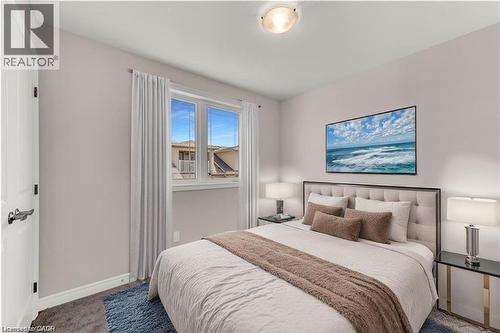 Bedroom featuring a large window with white trim, light-toned walls, and a ceiling-mounted light fixture - 19 Picardy Drive Unit# 9, Hamilton, ON 