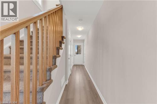 Entryway featuring wood-finish flooring and a carpeted staircase with wood banister - 19 Picardy Drive Unit# 9, Hamilton, ON 
