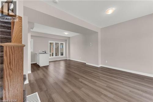 Open-concept living space featuring wood-finish flooring, neutral wall tones, and white trim - 19 Picardy Drive Unit# 9, Hamilton, ON 