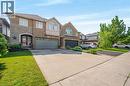 Two-story residence featuring a brick and stone facade, arched entry, and a garage - 409 Jacqueline Boulevard, Hamilton, ON 